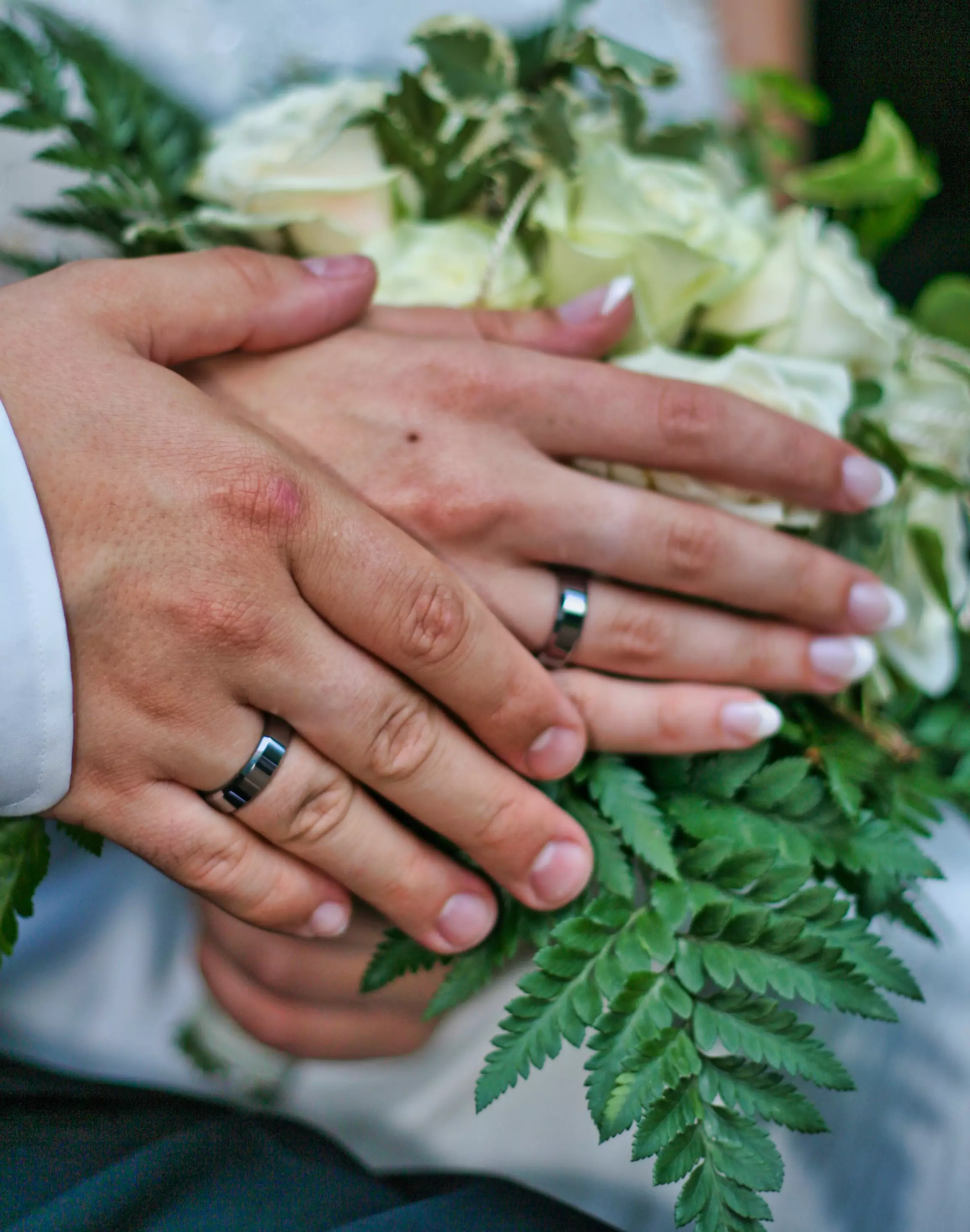 Zu sehen sind die H&auml;nde eines Ehepaars. Die Braut h&auml;lt einen Strau&szlig; in der Hand. Die Hand des Br&auml;utigams umschlie&szlig;t die Hand der Braut.